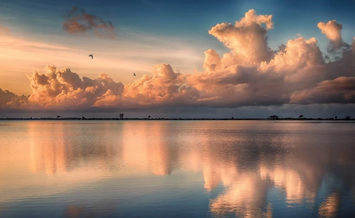 asymmetrical view of calm body water under clouds tropical