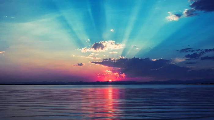 body of water sunset on horizon sea nature sky clouds calm 2k