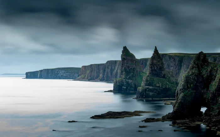 mountain besides body of water coast rock nature sea Scotland 2k