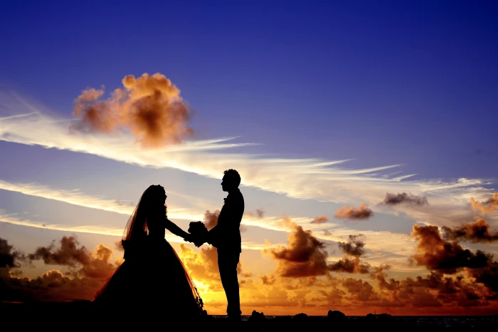 silhouette of couple standing under the clouds maldives sunset 2k