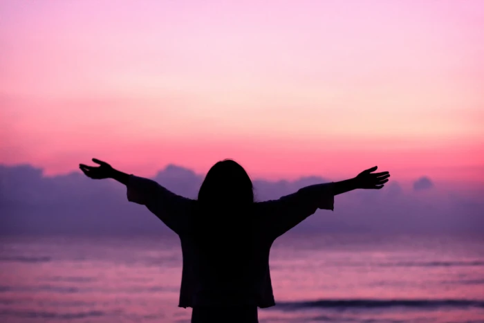 woman opening his arms wide in the seashore feast gratitude 2k