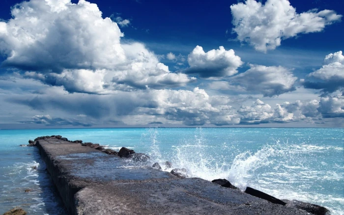 gray stone formation during daytime beach sky water sea cloud 2k