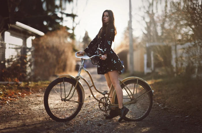 woman riding on brown beach cruiser bike standing road taken during daytime 2k