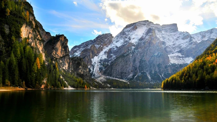 ice capped mountain beside calm water mountains near body of under cloudy sky during daytime 2k