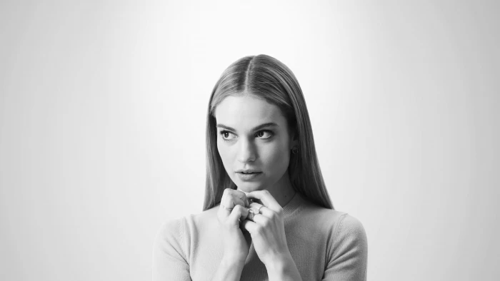 woman in crew neck shirt front of white wlal Lily James 2k 4k 5k