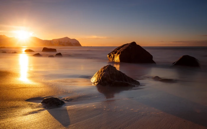 stones near sea during golden hour vikten norway 2k