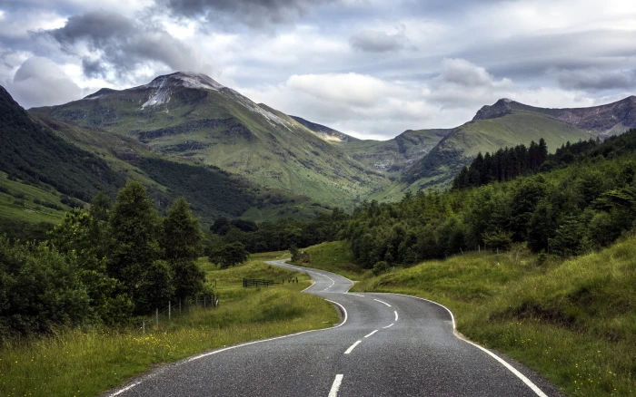black concrete road between green forest mountain nature landscape 2k