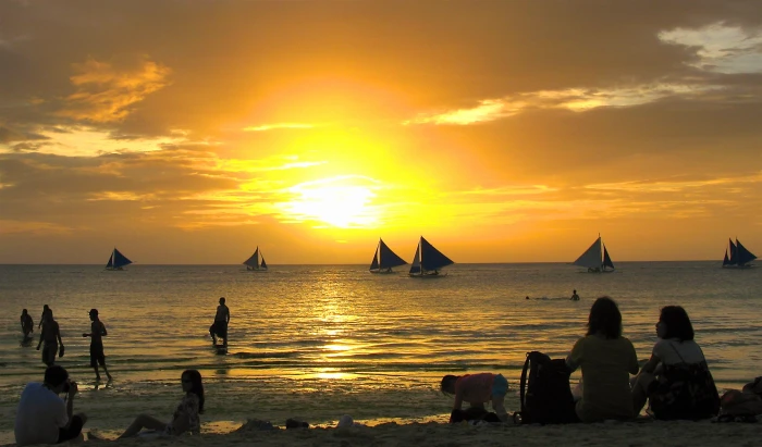 people sitting on seashore during golden hour boracay 2k