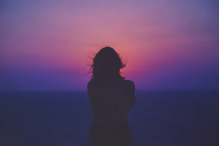 silhouette of a woman with pink and purple sky photo standing near beach 2k 4k