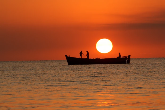 silhouette of persons riding row boat sunset sea water dawn 2k 4k
