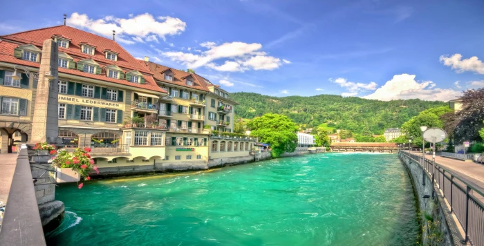 white and brown concrete building body of water Switzerland 2k