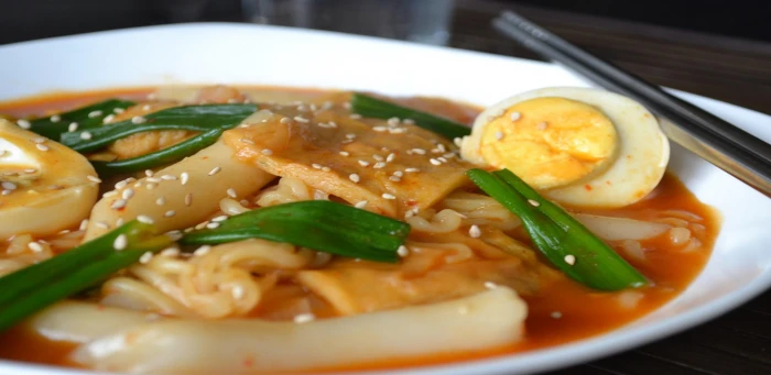 Korean Rabokki cooked food in white ceramic plate onion eggshardboiled 2k