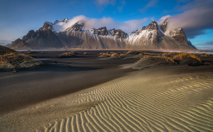 brown and white mountain surrounded by sand iceland 2k