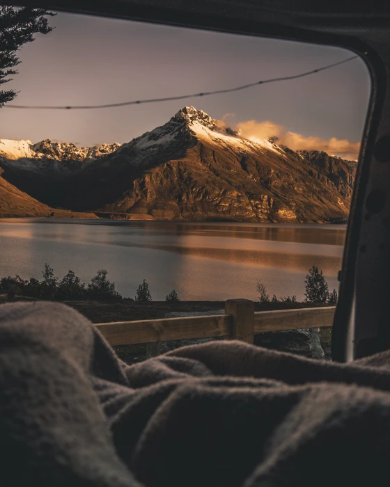 snow capped mountain beside lake view from vehicle door blanket 2k
