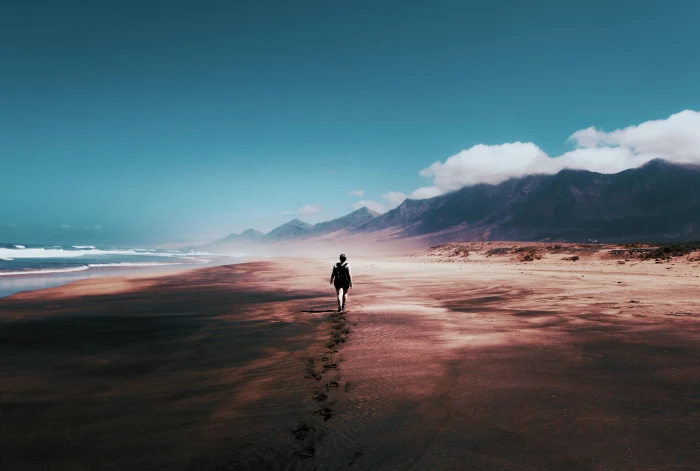 Photo of Person Walking on Deserted Island beach blue skies 2k 4k 5k