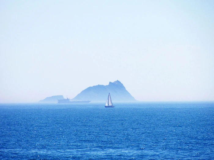 white and blue canoe on body of water near island during daytime 2k