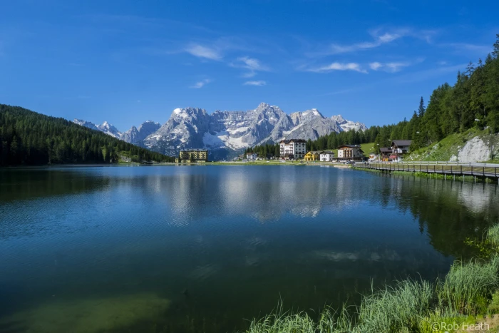 landscape photography of mountain near body water surrounded by pine trees lake misurina 2k