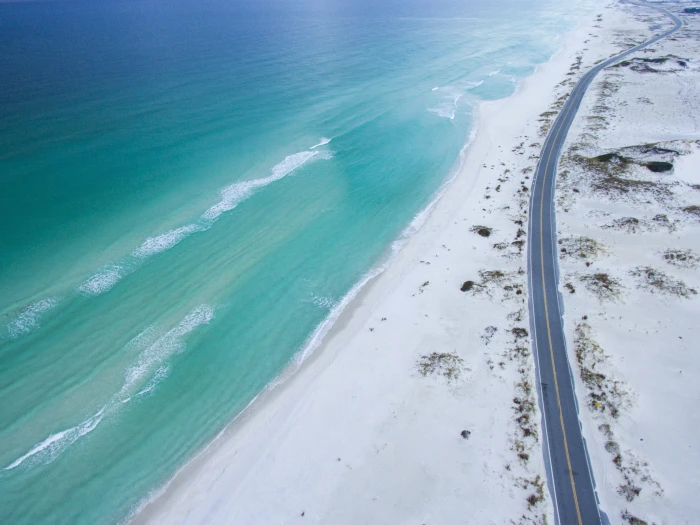 aerial photo of beach near road during daytime top view 2k 4k