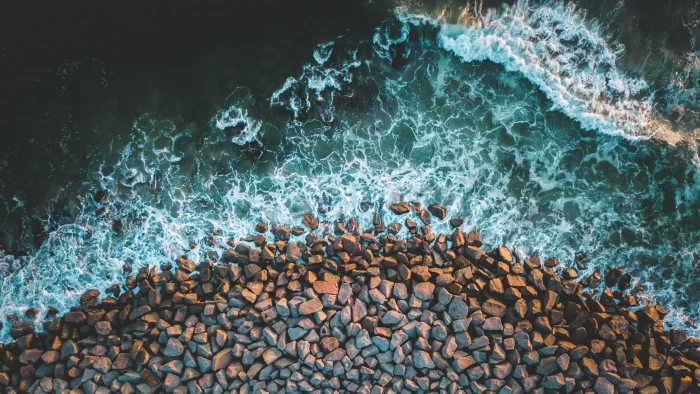 brown stones top view photo of gravels and ocean wave 2k 4k