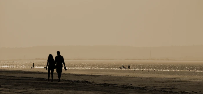 man and woman holding hands while walking near beach couple 2k 4k 5k