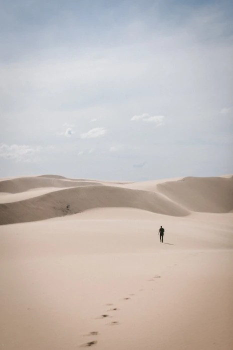 person waling on desert man walks during daytime dune 2k 4k