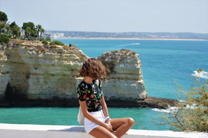 woman sitting on white rock formation near beach sea ocean 2k 4k 5k