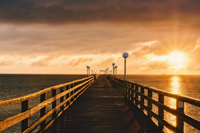 brown wooden dock surrounded by body of water during sunset binz 2k 4k 5k