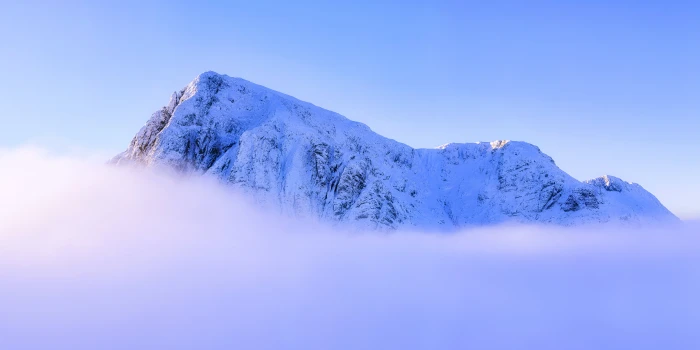 landscape photography of snowy mountain summit above clouds under clear sky during daytime glencoe scotland 2k 4k 5k 8k