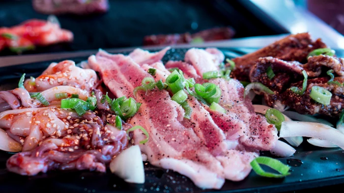 raw meat and octopus tentacles on black surface barbecue korean bbq 2k 4k 5k