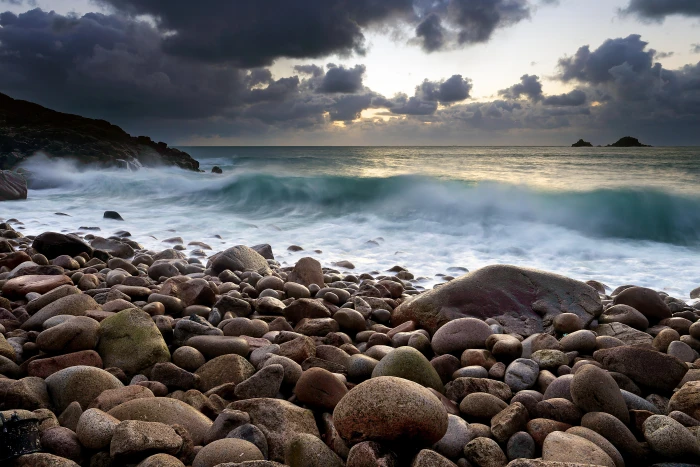 seashore stones near body of water during daytime Incoming sky 2k 4k 5k