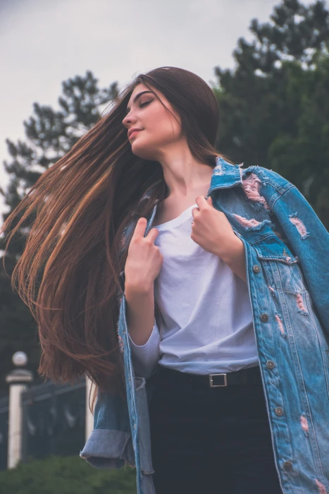 woman holding her white shirt flipping hair wearing and blue denim jacket 2k 4k