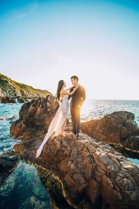 Man and Woman Standing on Brown Rock Under Blue Sky adult beach 2k 4k