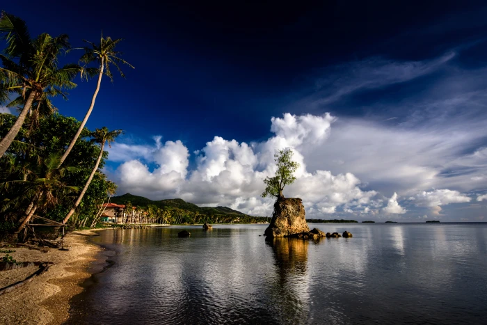 photo of brown island surrounded by body water near seashore 2k 4k 5k