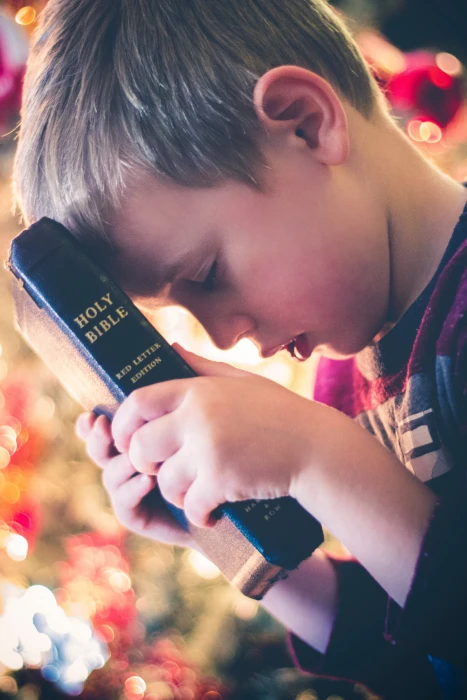 boy holding Holy Bible book reading religious hand bokeh 2k