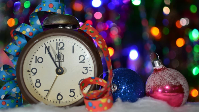 brown ta round white analog desk clock beside blue and pink baubles 2k 4k