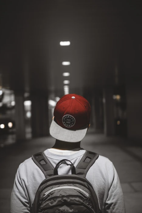 man wearing red cap facing the hallway person hat backpack 2k 4k
