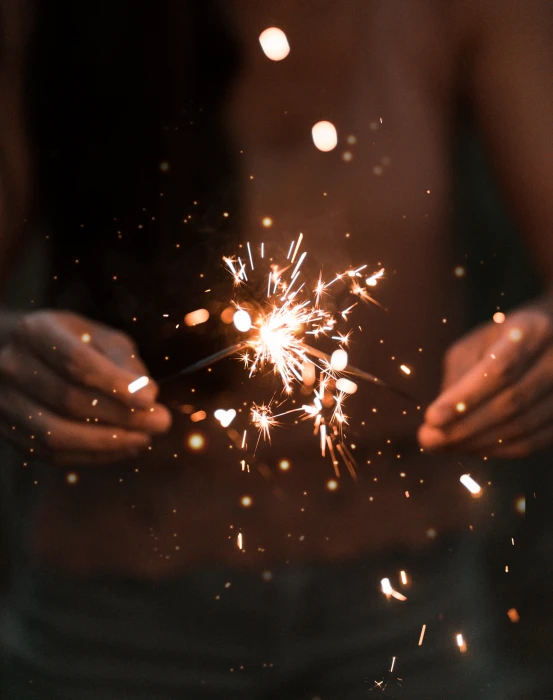 person holding fire works sparkler firework hand bokeh blur 2k 4k