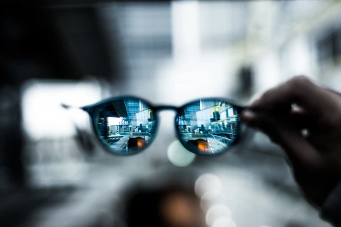 selective focus photography of person holding Clubmaster style sunglasses 2k