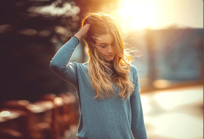 women s teal crew neck long sleeved shirt woman in gray top with her right hand on head
