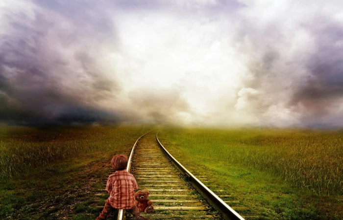 boy sitting on train rail under cloudy sky lighting color nuances 2k