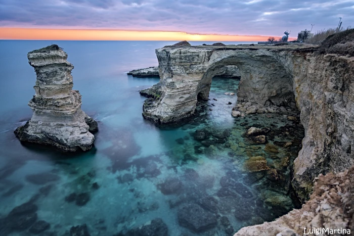 gray rock formation over body of water cliff arch seashore 2k 4k 5k