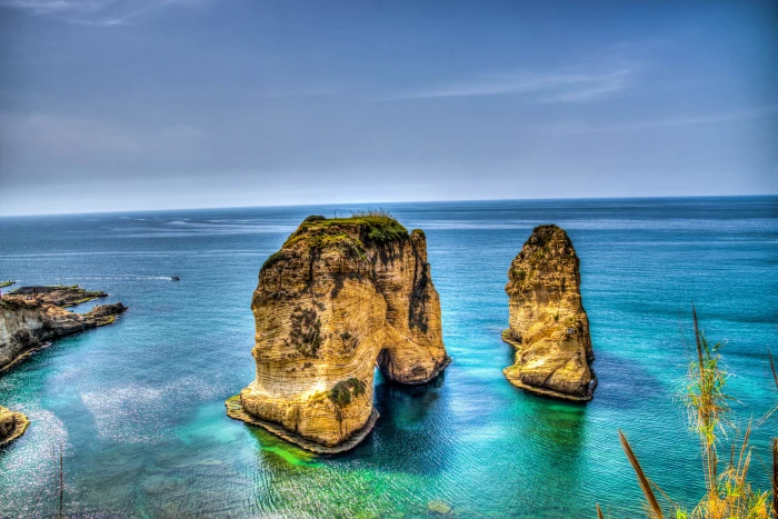 two yellow and black rock formation at blue sea under sky during daytime beirut lebanon 2k 4k 5k