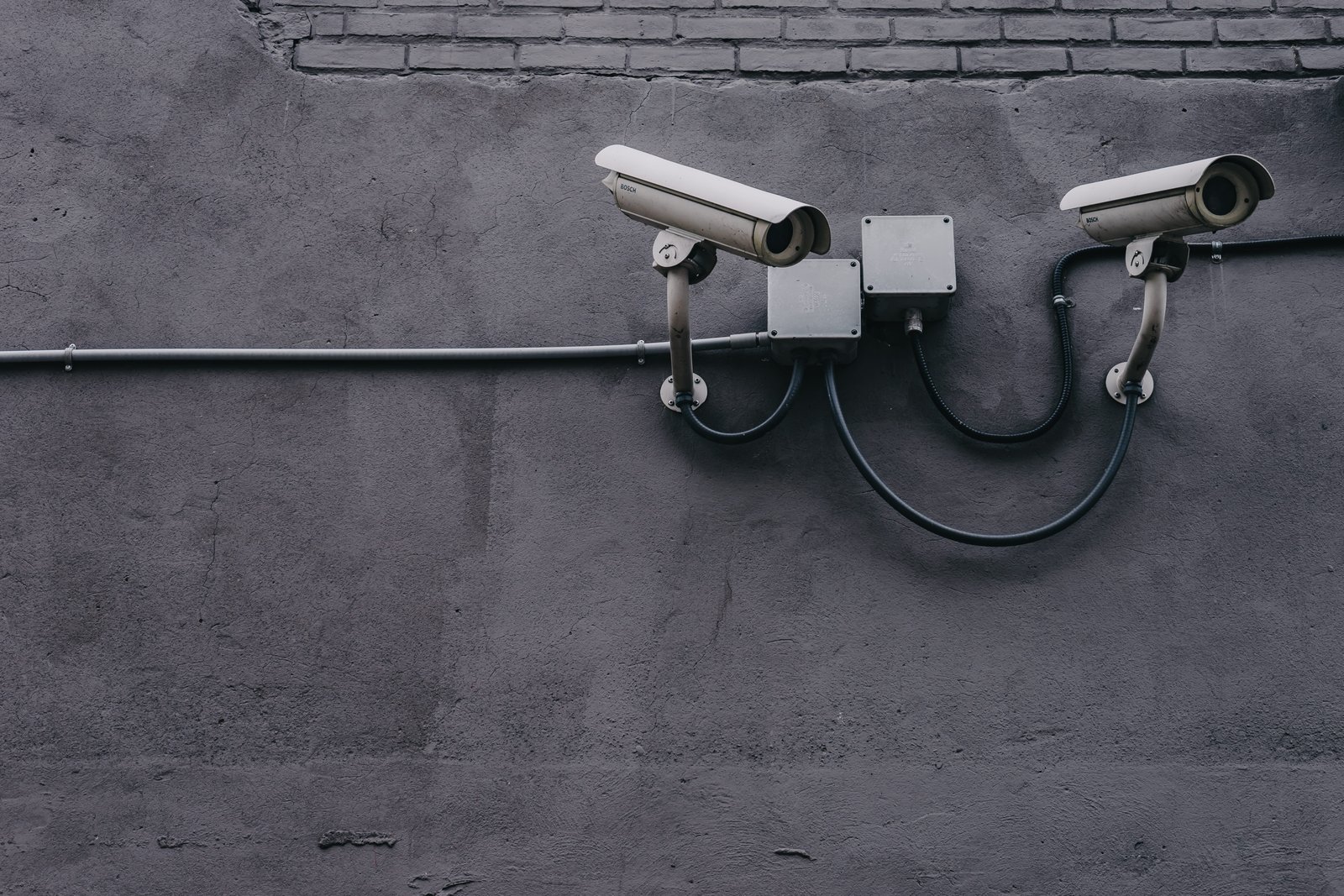 Two Gray Bullet Security Cameras cyber data equipment pavement 2k 4k 5k