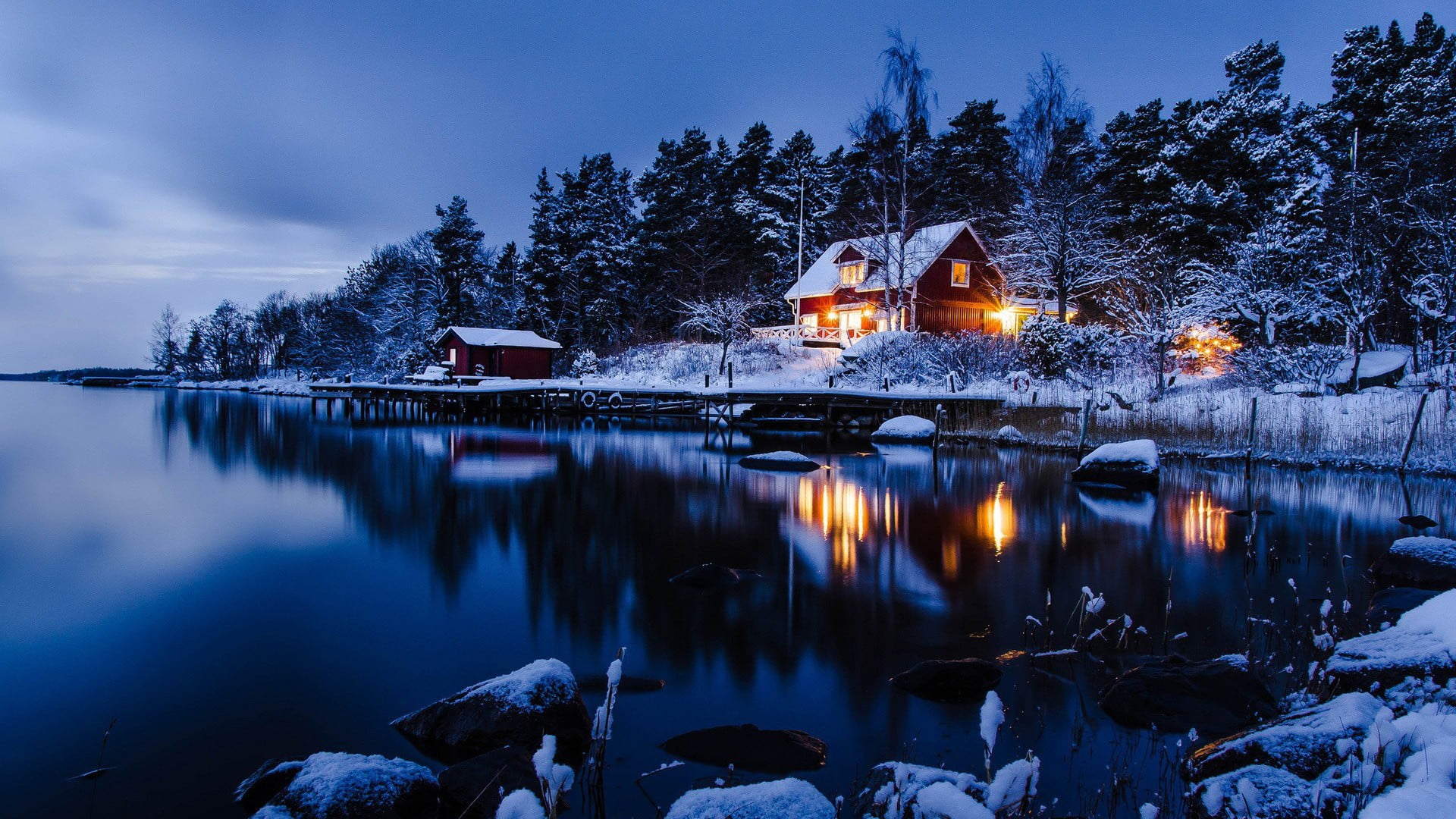 body of water lighted house near calm during golden hour 31