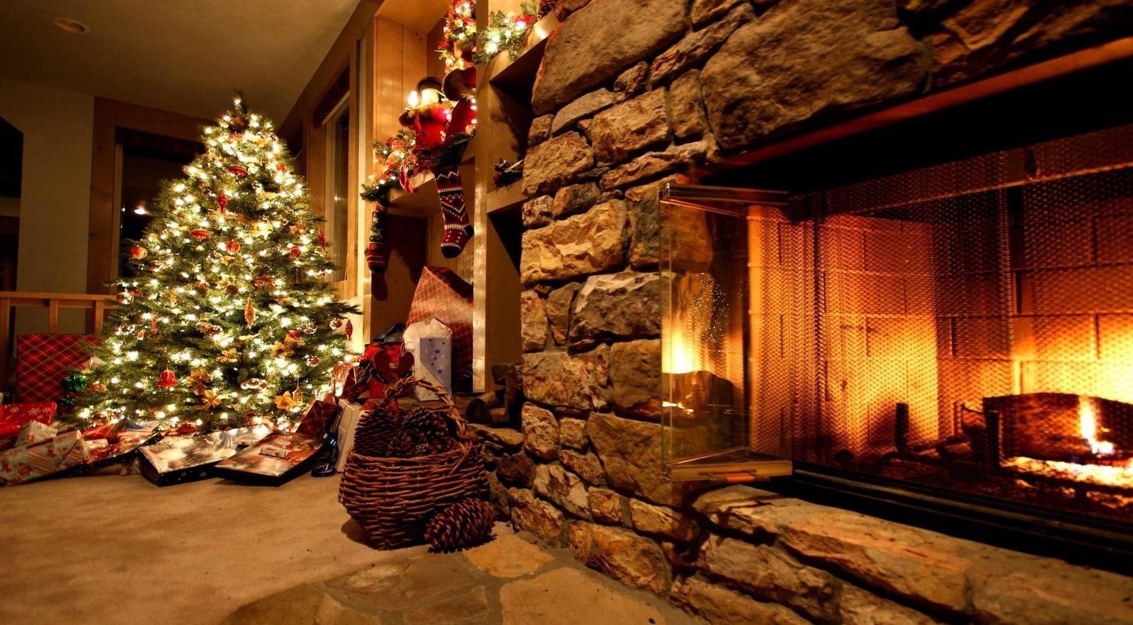 green Christmas tree with lights and fireplace ornaments gifts