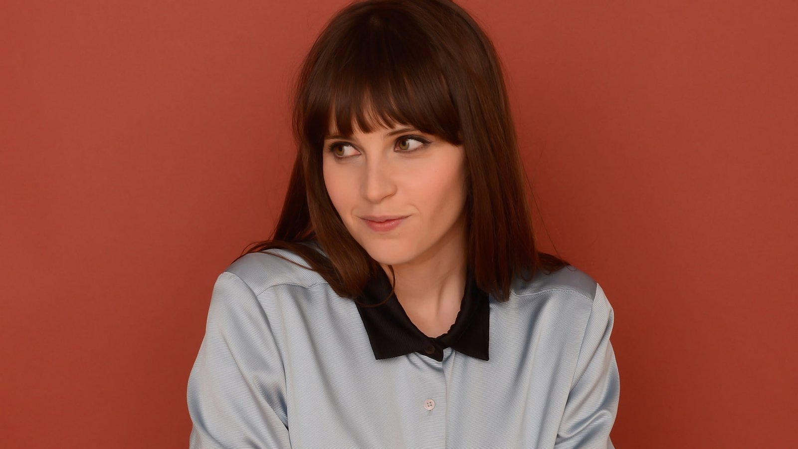 Felicity Jones actress brunette red background brown eyes