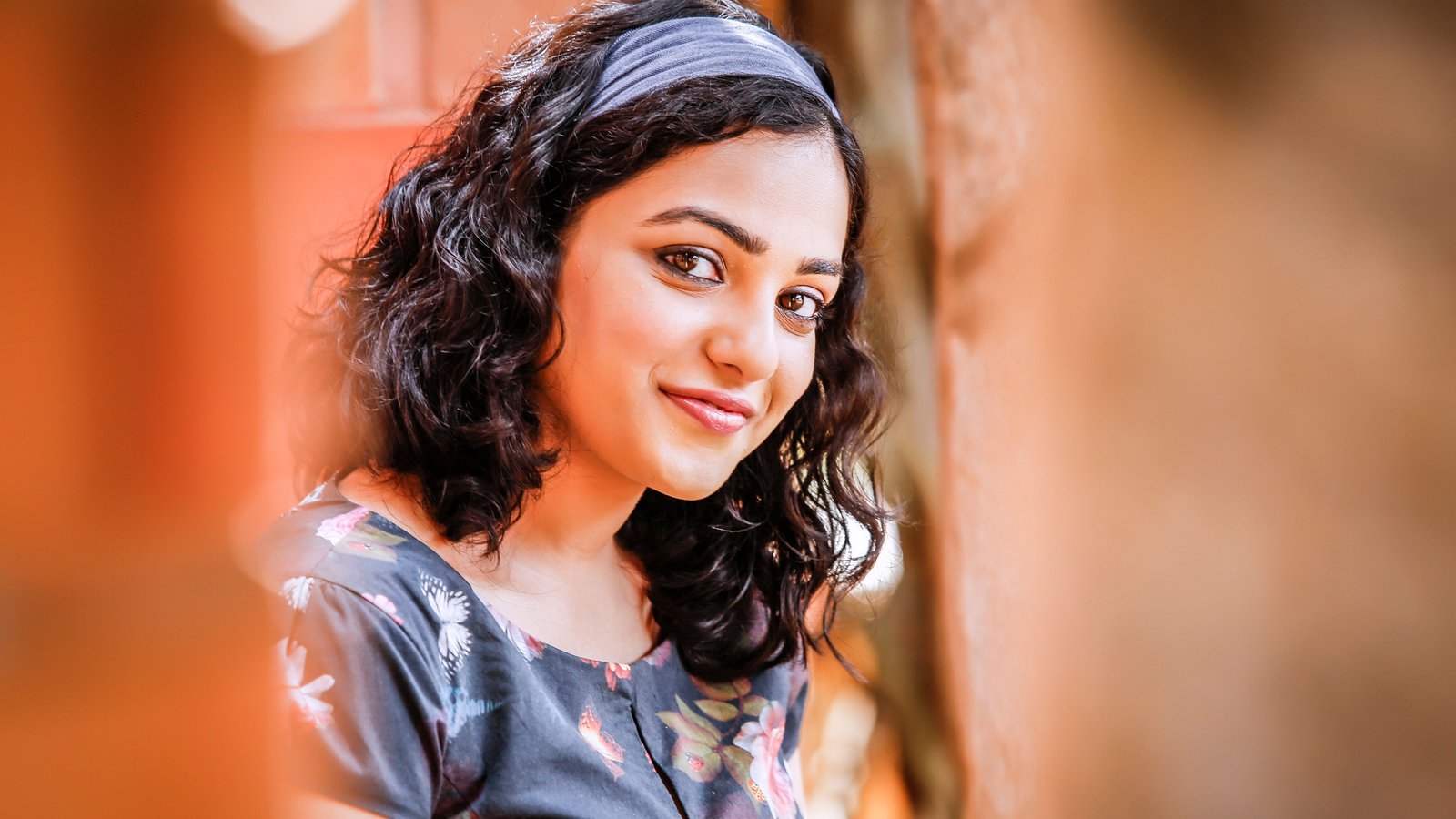 shallow focus photography of woman wearing black floral t shirt while smiling at the camera during daytime 2k 4k 5k