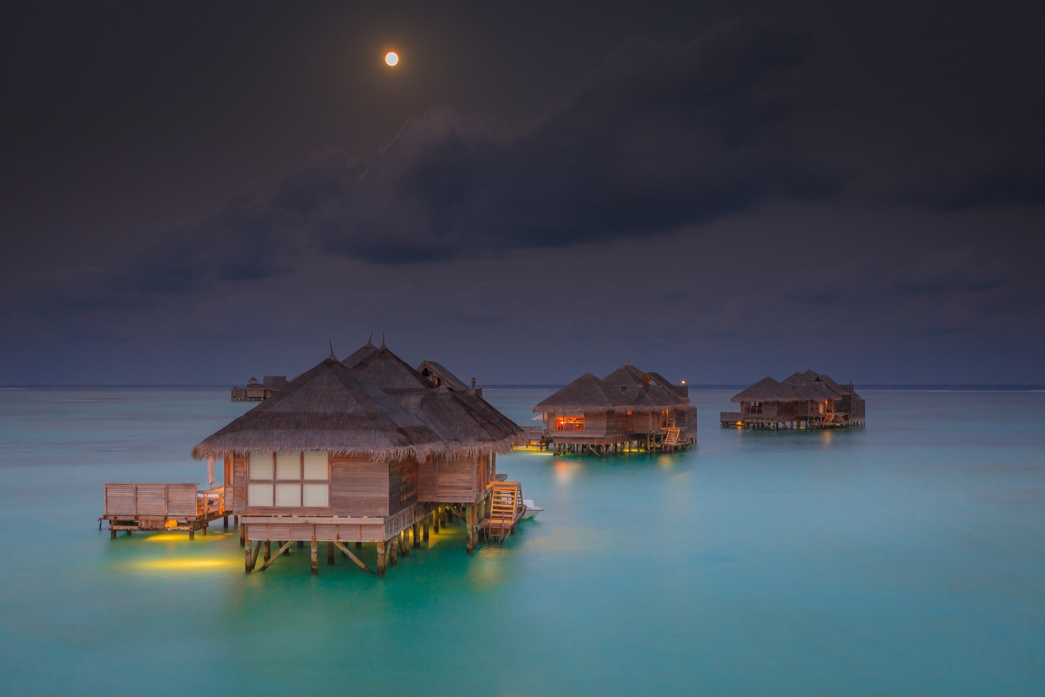 brown and black nipa huts in the middle of ocean illustration 2k