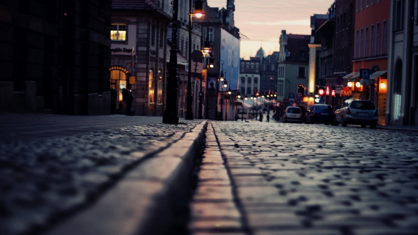 gray concrete pavement close up photography of near buildings and street lights