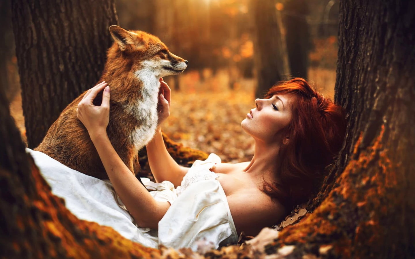 brown and white fox woman lying on tree trunk with red women